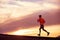 Male runner silhouette, running into sunset