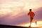 Male runner silhouette, running into sunset