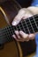 Male\'s hand on a classical guitar fretboard