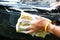 Male`s hand holding sponge with bubble foams for carwash