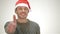 The male in Santa hat smiling and showing thumb