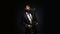 Male saxophonist performs alone with a saxophone playing in studio on a black background. Musician in suit plays the