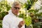 Male scientist in clean suit inspecting plant leaves