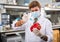 Male scientist injecting reagent from syringe into bell pepper, performing scientific researching of food genetic