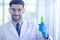 A male scientist wears a white coat and is researching chemicals in the laboratory
