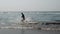 Male in the sea near the coast. Attractive man in sea splashing water and posing to camera. Smiling man having fun in