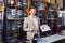 Male seller demonstrating shirts in menâ€™s cloths store