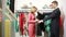 Male seller offers women dress. blonde chooses clothes