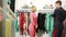 Male seller offers women dress. blonde chooses clothes