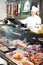 Male seller posing with wursts in butchery