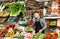 male seller weighing grapes in grocery shop