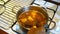 Male senior is cooking a homemade beef soup with potato and onion in a metal pot.