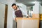 male shop assistants pack ordered furniture using cardboard boxes before sending