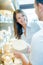 Male shop worker showing whole cheese to customer