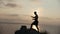 Male silhouette doing morning yoga on the big stone by the sea at sunrise