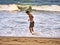 Male silhouette goes in the sea water on a sand beach. Young adult boy on the beach - beautiful background with copy space