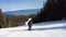 Male skier dressed in black, man skiing down a tree lined snowy mountain piste or slope on fresh snow