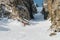 A male skier freerider with a beard descends the backcountry at high speed from the slope