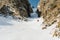 A male skier freerider with a beard descends the backcountry at high speed from the slope