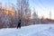 Male skier rides in the winter park at sunset