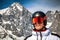 Male skier with ski goggles and helmet and snowy peak at background
