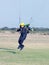 Male skydiver coming in for landing on grass with open brightly