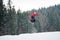 Male snowboarder jumping over the slope in winter day