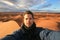 Male solo traveler taking selfie in Sahara desert, Morocco.