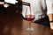 Male sommelier pouring red wine into long-stemmed wineglasses.