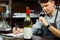 Male sommelier tasting red wine and making notes at bar counter