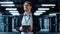 Male IT Specialist Walks Between Row of Operational Server Racks in Data Center. Engineer Uses