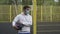 A male sportsman basketball player with a ball in a mask looks on the sides in a closed playground alone in quarantine