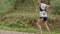 Male sportsman in shorts and T-shirt running on trail in forest