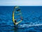 Male sportsman windsurfing in blue sea