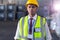 Male staff in hardhat and reflective jacket standing in warehouse