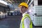 Male staff in hardhat and reflective jacket standing in warehouse