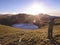 A male standing on a higher place by the Jiaming lake formed by glacial movement during the last ice age, and taking photos.