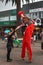 A male stilt walker in red clown costume shaking hands