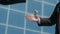 Male strong handshake of people in classic black suits, against the background of a modern office building. Close-up