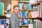 Male student chooses a book in the library