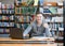 Male student with laptop showing thumbs up in the university library