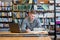 Male student with laptop studying in the university library