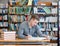 Male student with open book working in a library