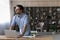 Male student stand by desk with laptop look away think