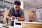 Male Student Studying For Carpentry Apprenticeship At College Using Wood Plane