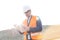 Male supervisor reading clipboard at construction site on sunny day