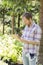 Male supervisor writing on clipboard at plant nursery