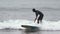 Male surfer athlete riding wave, surfing in cold splashing waves of Pacific Ocean. Slow motion shot