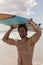 Male surfer carrying surfboard on his head at beach