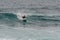 Male surfer glides on a surfboard on a wave